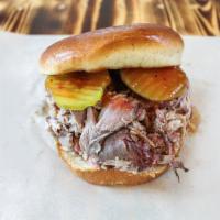 Pulled Pork Sandwich · Slow smoked pork shoulder, dressed in a tangy sop sauce, served on a toasted bun, our house-...