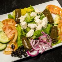 Greek Salad · Topped with feta cheese, stuffed grape leaves, black olives.