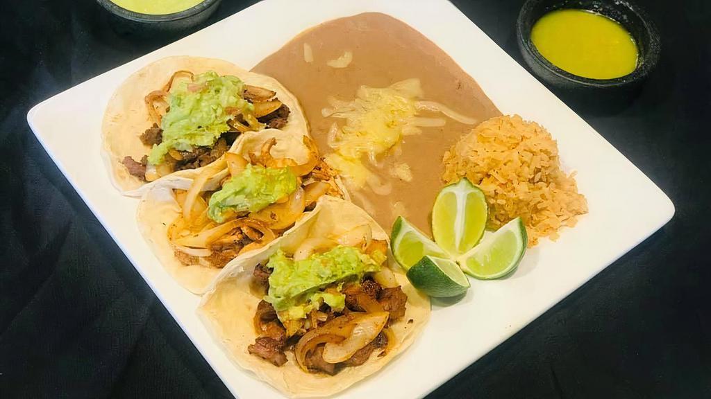 Plato De Taco / Taco Plate · Tres tacos con tu elección de carne. Servidos con arroz y frijoles. / Three tacos with your choice of meat. Served with rice and beans