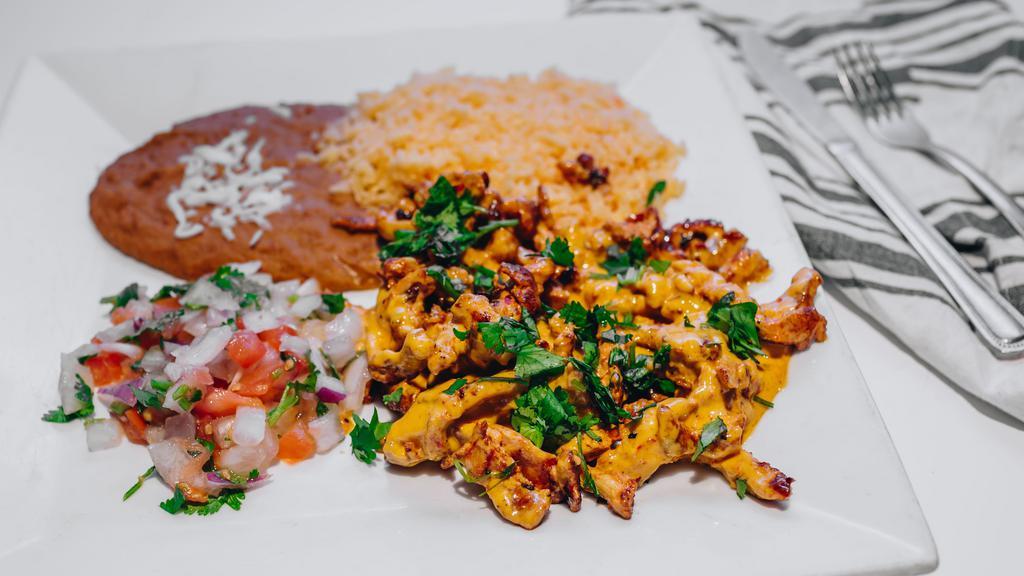 Tiras De Pollo · Strips of grilled chicken topped with cilantro, and sautéed with a savory combination of cheese dip and chipotle cream, served with rice, beans, flour tortillas and pico de gallo.