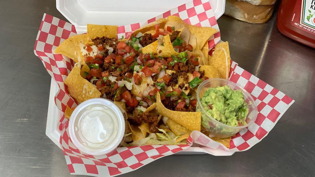 Nachos · Nacho cheese with pico of gallo, choose any meat, steak, chicken, chorizo. With sour cream and guacamole.