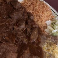 Chile Colorado · Cooked beef tips with red sauce served with rice, beans, and tortillas.