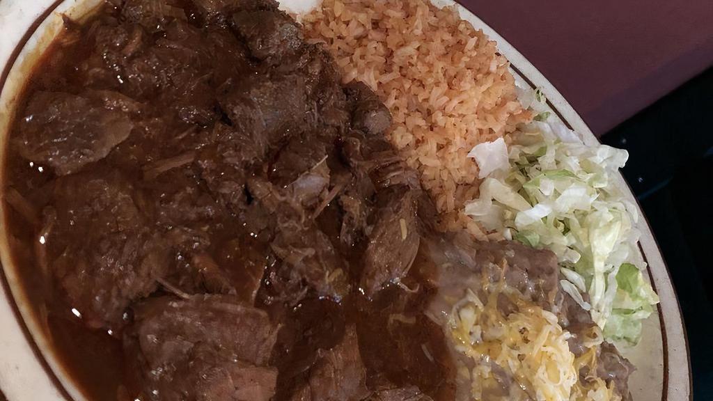 Chile Colorado · Cooked beef tips with red sauce served with rice, beans, and tortillas.