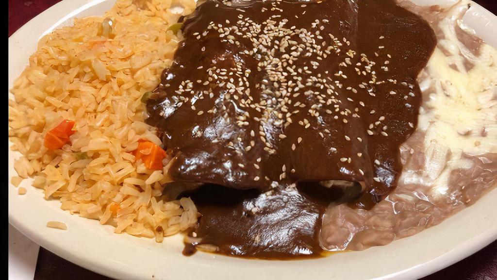 Enchiladas De Mole · Three chicken or beef enchiladas covered with dark mole sauce, sour cream and fresh cheese. Served with rice, black beans and sweet plantains.