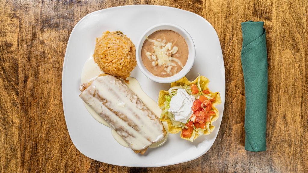 Chimichanga · Flour tortilla filled with ground beef or chicken, soft or fried with cheese sauce served with rice, beans, lettuce, tomatoes and sour cream.