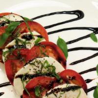 Caprese · Mixed greens, tomatoes, mozzarella, basil, pesto, balsamic, salt + pepper.