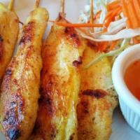 Satay Chicken · Chicken breast slices marinated in a house sauce grilled on a bamboo skewer. Served with pea...
