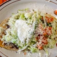 Huarache Mexicano · Thick oblong homemade corn tortilla with your choice of meat along grilled onion, beans, let...