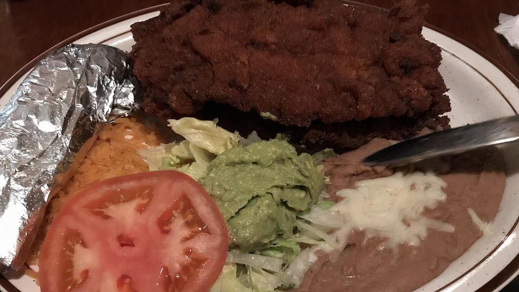 Milanesa · Breaded chicken breast or steak. Served with rice, beans, lettuce, guacamole, tomato, and tortillas.