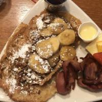 Croissant French Toast · Dusted with powdered sugar and served with syrup, honey butter and toasted pecans. Add caram...