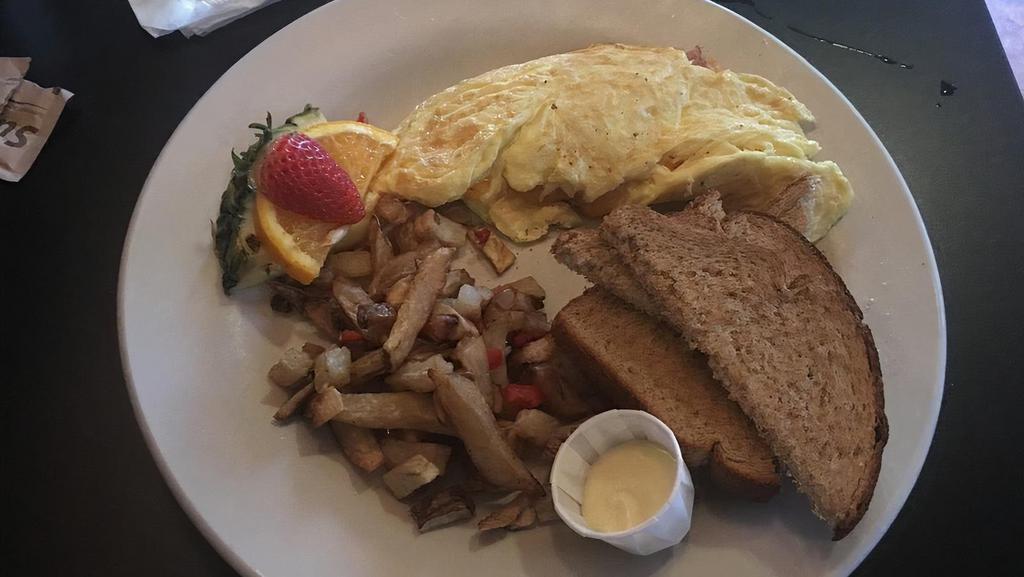Four Egg Omelet · Served with breakfast potatoes or cheese grits and choice of bread.