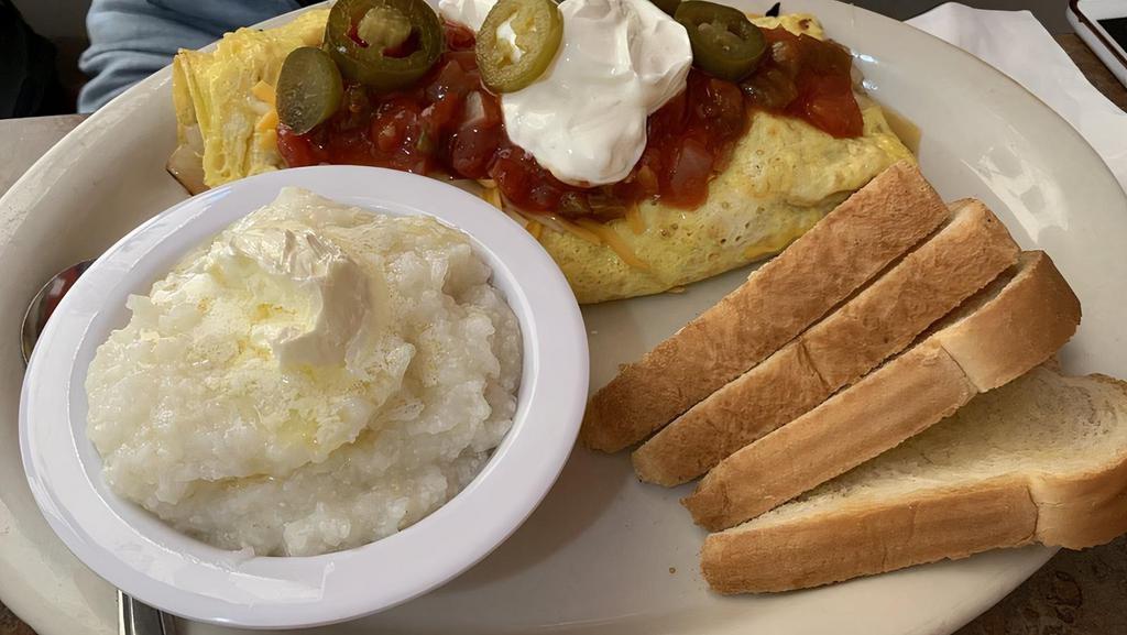 Southwestern Omelette · 3 eggs, ham, mushrooms, onions, tomatoes, green peppers, jalapenos, cheddar cheese topped with sour cream and salsa. Served with toast and a side.