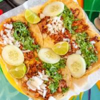 Tacos Al Pastor · Charbroiled marinated pork, four corn or two flour tortillas, green hot sauce, and refried b...