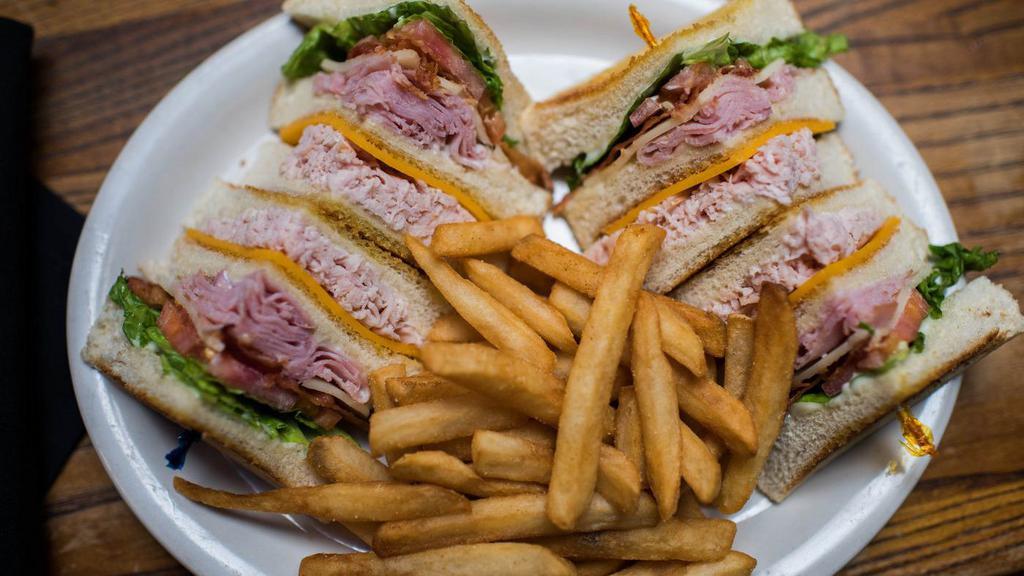 Traditional Club · Sweet honey ham, smoked turkey breast, crisp bacon, swiss and cheddar cheeses layered between three slices of thick Texas toast with lettuce, tomato and mayonnaise.