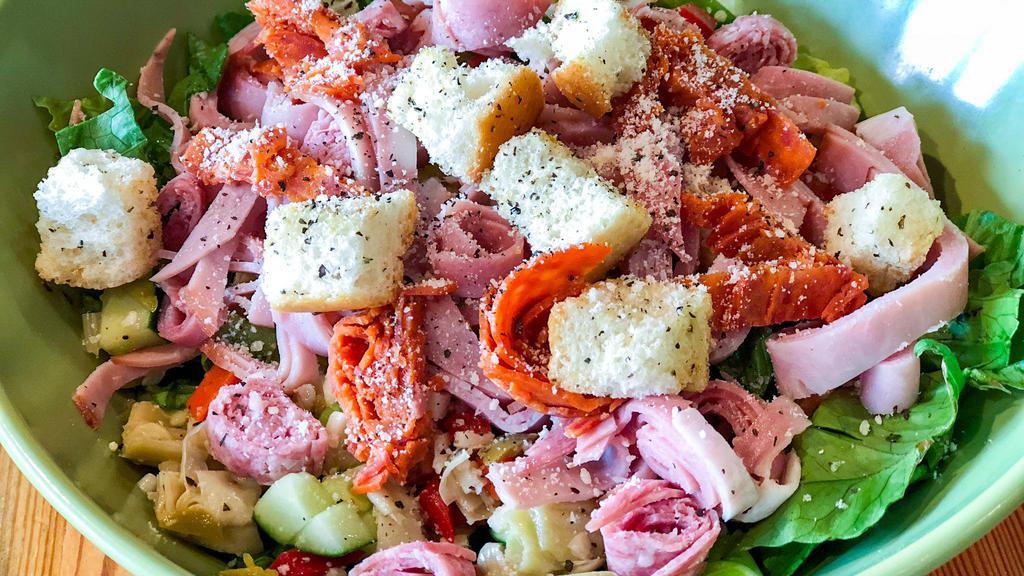The Italian Chopped Salad · Prosciutto, ham, and salami with artichoke, cucumber, green onion, diced tomato, olive salad, Parmesan and fresh Mozzarella. Served over romaine and arugula with cracked pepper and tossed in house-made Italian dressing.