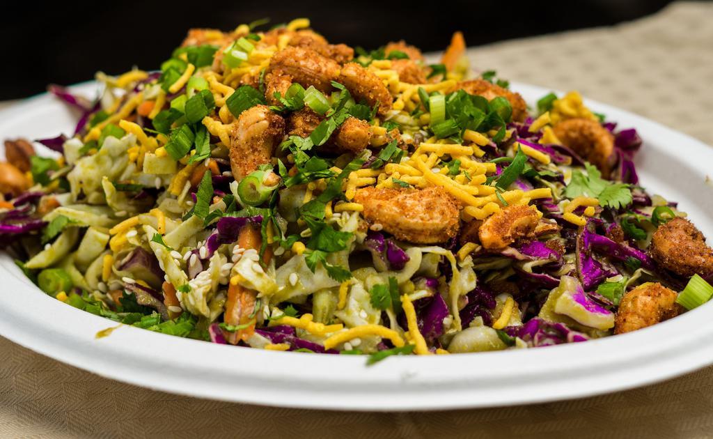 Desi Salad · Shredded white & red cabbage, carrots, scallions, and roasted cashews topped with toasted sesame seeds, cilantro, and served with a cumin-lime vinaigrette.