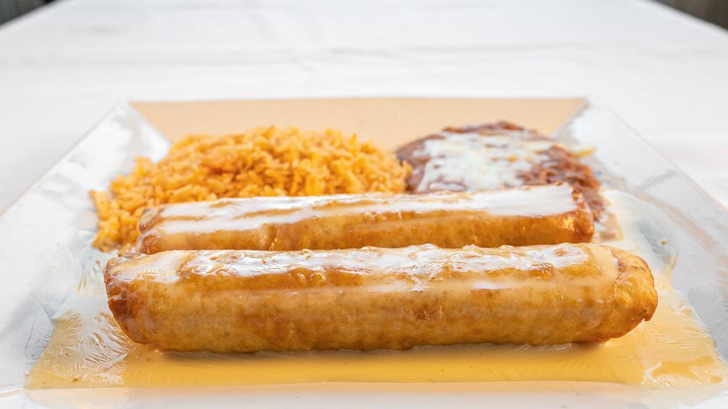 Chimichanga Dinner · Two Chimichangas, beef or chicken, fried or soft, and covered with queso dip.  served with rice and beans on the side.