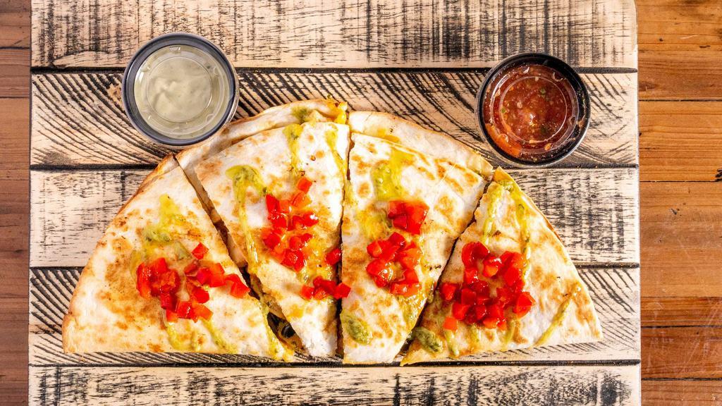 Spicy Southwest Quesadilla · Marinated grilled chicken, our black bean corn salsa, cilantro, three cheese blend of cheddar, pepper Jack, and Parmesan, and chipotle sauce. Topped with avocado sauce, served with salsa on the side.