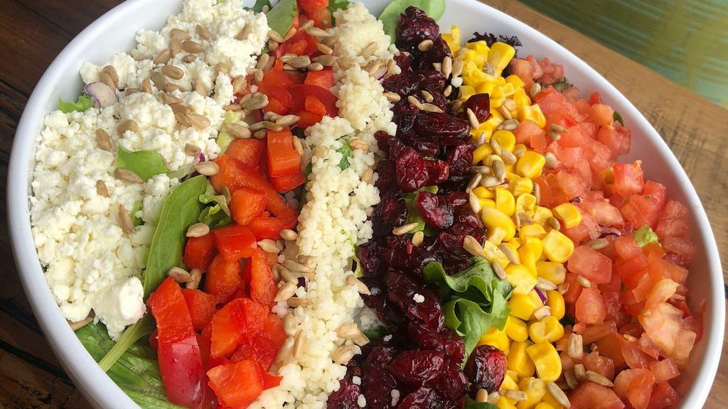 Signature Chopped Salad · Organic arugula, spring mix, pearl couscous, feta, red peppers, corn, dried cranberries, tomatoes, and sunflower seeds.
