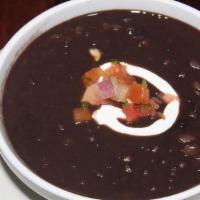 Black Bean Soup · Expertly prepared black bean stew, topped with sour cream and pico de gallo.