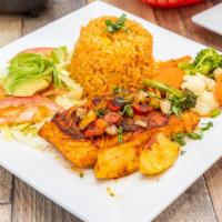 Grill Fish Dinner · A grilled fish fillet topped with grilled onions and bell peppers. Served with a rice, steam...
