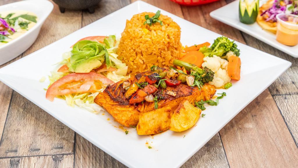 Grill Fish Dinner · A grilled fish fillet topped with grilled onions and bell peppers. Served with a rice, steam veggies, lettuce, tomatoes, and avocado.