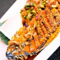The Palace Tilapia · A fried whole tilapia sautéed in a sauce with onions, tomatoes, cilantro, lite sour cream an...