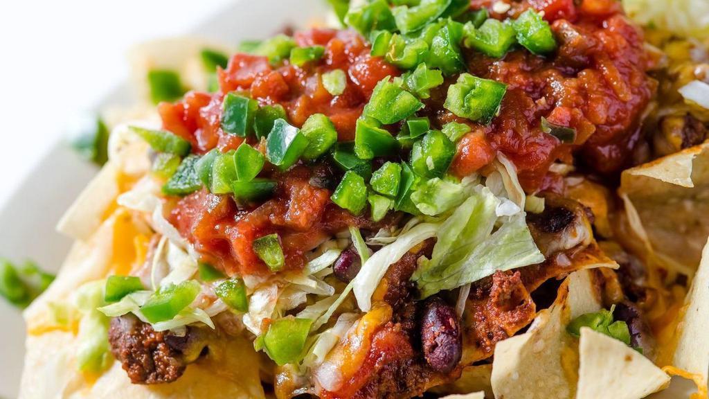 Steakhouse Nachos · Fresh tortilla chips layered with chili and melted cheese, topped with lettuce, salsa, and jalapinos, sour cream upon request.