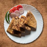 Potato Paratha · Unleavened layered wheat bread stuffed with potatoes, topped with melted butter.
