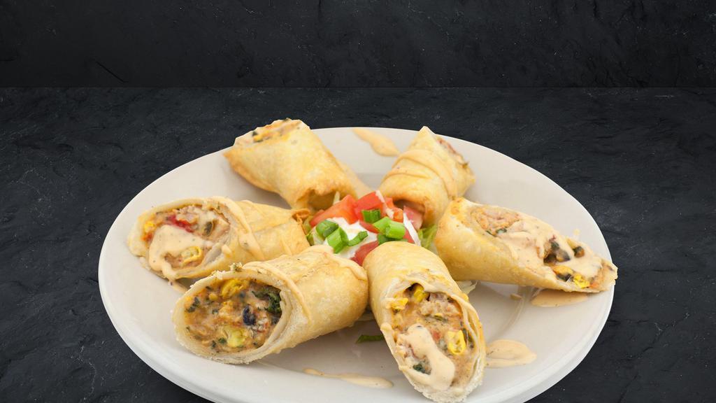 Southwest Egg Rolls · Crispy egg rolls filled with southwest chicken and black bean corn salsa, drizzled with tangy chipotle ranch dressing.