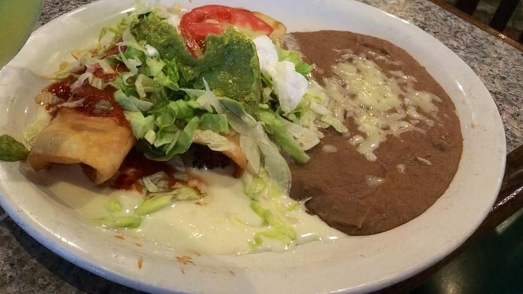 Chimichanga · One flour tortilla, soft or fried, filled with chicken or beef tips, topped with nacho cheese, lettuce, tomatoes, sour cream, and guacamole. Served with beans or rice.