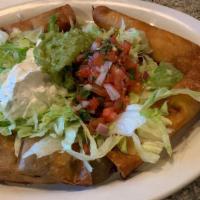Taquitos Mexicanos · Four fried corn taquitos: two beef and two chicken, served with lettuce, guacamole, and pico...