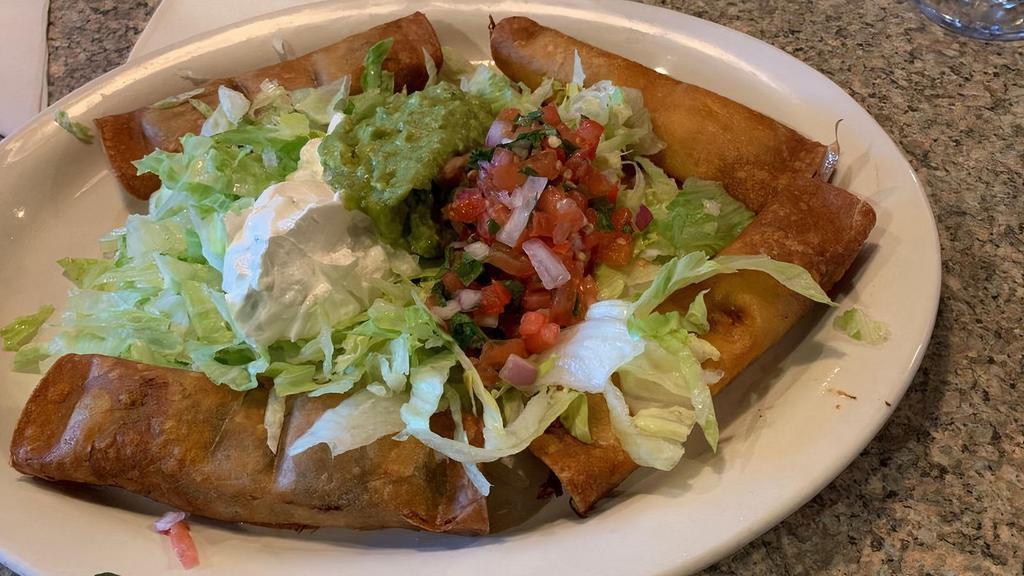 Taquitos Mexicanos · Four fried corn taquitos: two beef and two chicken, served with lettuce, guacamole, and pico de gallo.