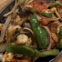 Fajitas · Sliced tender beef or chicken cooked with bell peppers, green onions, and tomatoes.