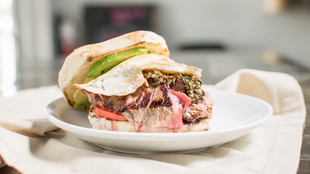 Churrasco · Steak* or Chicken, avocado, soft fried egg, tomato, chimichurri, aioli on our house baked bread. 

*Unless otherwise specified, steak will be cooked medium.