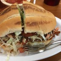 Torta Cubana · Served with mayonnaise, jalapeños, avocado, lettuce, tomatoes, and beans. All between two pi...