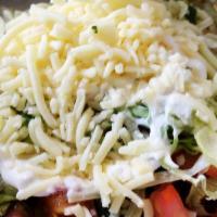 Tostada · Fried corn tortilla topped with beans, lettuce, tomatoes, cheese, sour cream, cilantro, and ...