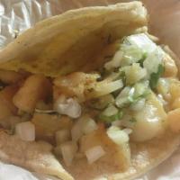 Taco Fish (Pescado) · Served on two soft corn tortillas. Topped with onions and cilantro.