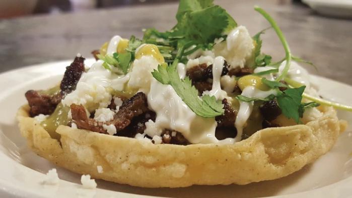 Sopes · A small bowl of homemade corn tortilla; with beans, your choice of fajita chicken, steak, carnitas or al pastor; topped with green salsa, sour cream, queso fresco and garnished with cilantro.
