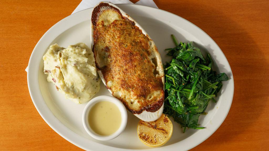 Baked Sea Scallops · Large sea scallops are combined with garlic, butter, crab meat and bread crumbs, then baked to perfection and served with mashed potatoes and sautéed spinach