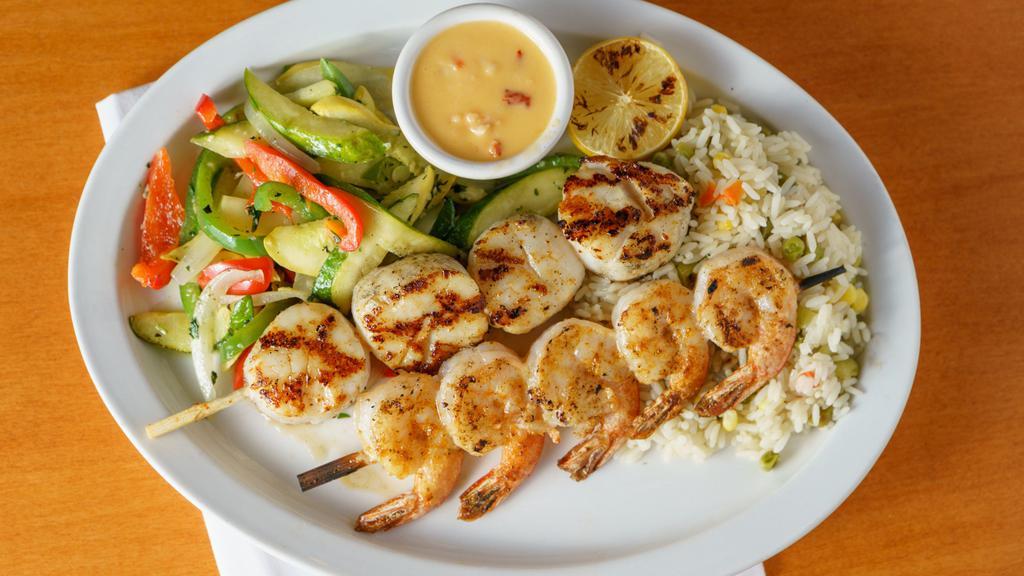 Scallop Kabob · Seasoned and grilled  scallop kabob skewer, served over herb rice and mixed vegetables, dressed with lobster cream sauce