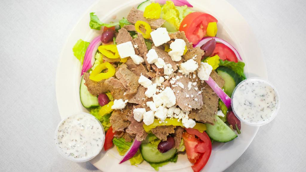 Greek Gyro Salad · Romaine lettuce, roma tomatoes, cucumbers, purple onions, feta cheese, kalamata olives, banana peppers, topped with gyro meat and cucumber sauce.