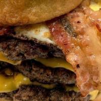 Gorilla Burger · Three huge fresh beef, fried egg, bacon, cheese topped with two onion rings (fries included).