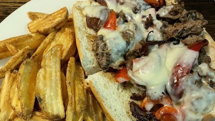Steak Philly · Thin sliced steak sauteed with mushrooms, onions, peppers and provolone cheese served open face on a hoagie roll with lettuce and tomato.