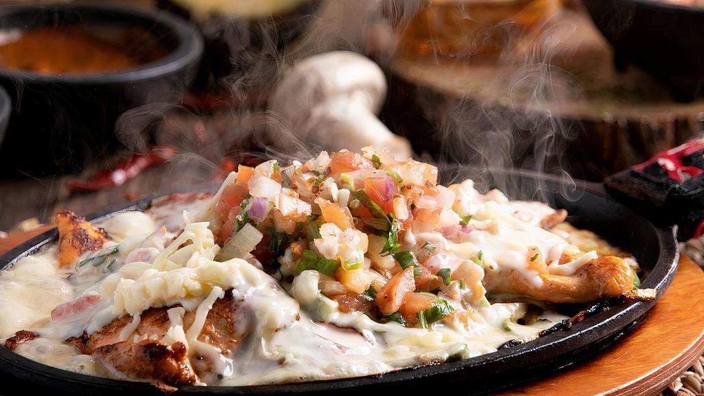 Pollo Loco · Grilled chicken breast cooked with bell peppers and onions. With pico de gallo and nacho cheese on top. Served with rice, beans, and tortillas