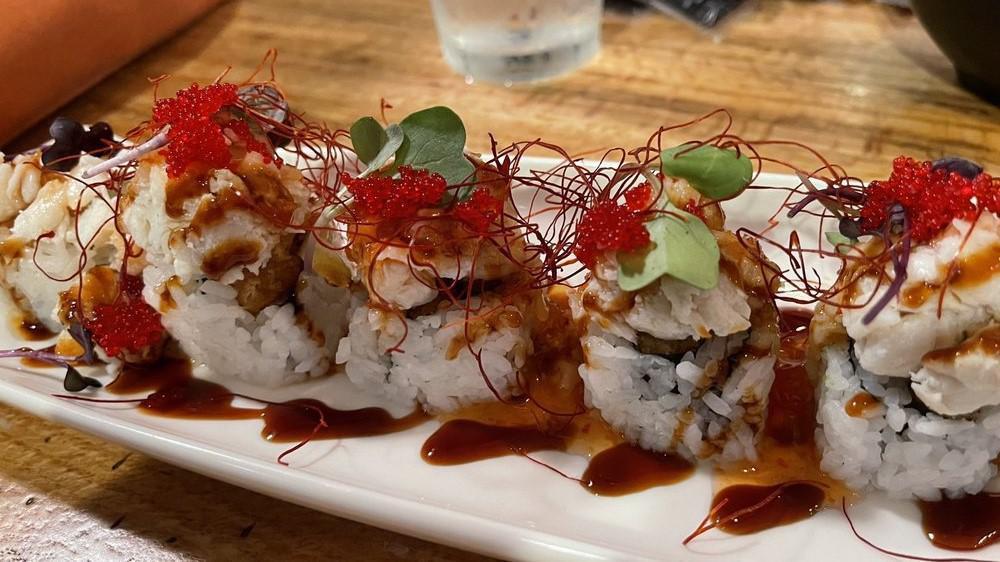 Saltwater Crab Roll · Shrimp tempura, cucumber, topped with lump crab, eel sauce, sweet chilli, thin dry chilli, microgreens, red tobiko.