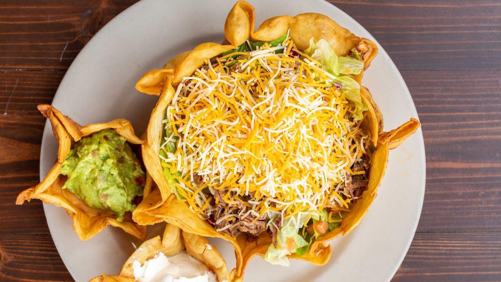 Taco Salad · Choice of shredded beef or shredded chicken with beans, salad, cheese, tomatoes, fresh guacamole and sour cream. Served in a crispy tortilla bowl.