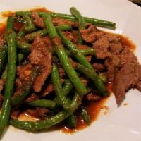 (L) Prik Khing · Spicy. Stir-fried string beans and lime leaves in a homemade red chili paste sauce. Served w...