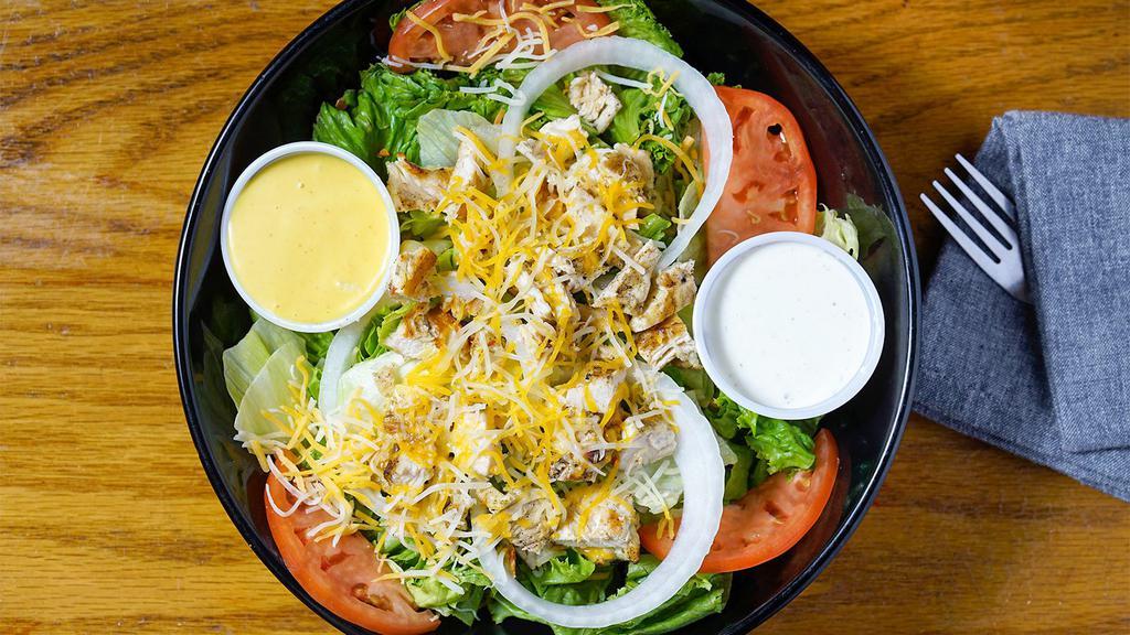 Grilled Chicken Salad · Sliced grilled chicken breast with crispy romaine lettuce, tomatoes, onions, cucumbers, croutons, shredded cheese and a side of homemade corn salsa. Served with a side of your choice of dressing.
