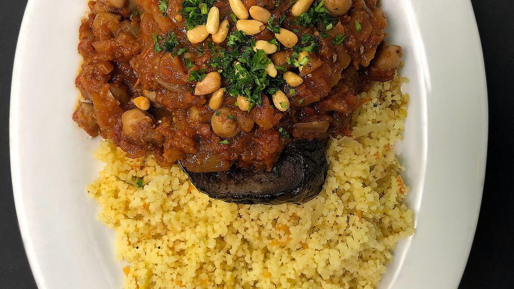 Moussaka (Lunch) · Roasted Bharat spiced eggplant steaks topped with ripe tomato, chickpeas, diced onion, and minced garlic sauce, served over Moroccan couscous and garnished with toasted pine nuts.